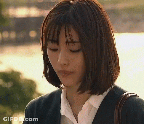 A Woman With Short Hair Is Wearing A Suit And A White Shirt And Is Looking Down . GIF