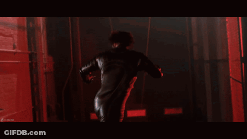 A Woman With Spikes On Her Body Is In A Dark Room With Red Lights GIF