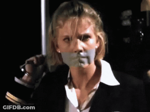 A Woman With Tape On Her Mouth Is Holding A Knife . GIF