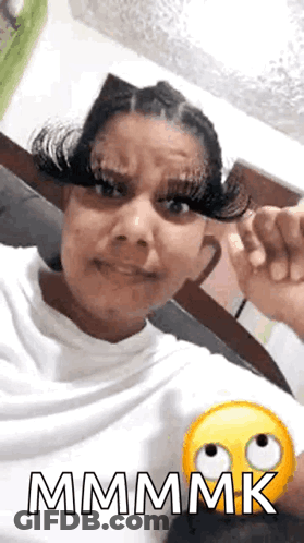 A Woman With Very Long Eyelashes Is Making A Funny Face And Giving A Thumbs Up . GIF
