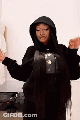 A Woman With Very Long Hair Is Wearing A Black Hoodie And A T-Shirt . GIF