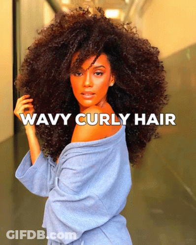 A Woman With Wavy Curly Hair In A Blue Robe GIF
