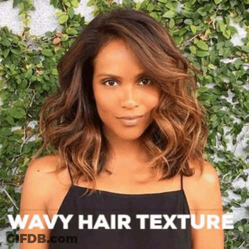 A Woman With Wavy Hair Is Wearing A Black Tank Top And Standing In Front Of A Wall . GIF