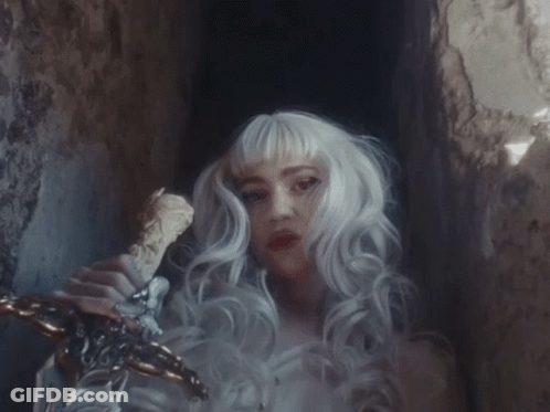 A Woman With White Hair Is Holding A Sword In Her Hand GIF