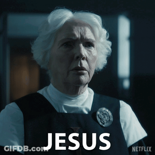 A Woman With White Hair Is Standing In Front Of A Sign That Says Jesus On It GIF