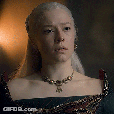A Woman With White Hair Is Wearing A Necklace And Earrings . GIF