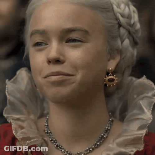 A Woman With White Hair Wearing A Necklace And Earrings Smiles GIF