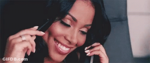 A Woman With White Nails Is Smiling While Talking On A Cell Phone GIF