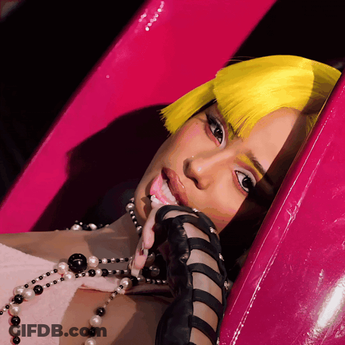 A Woman With Yellow Hair And A Pearl Necklace GIF