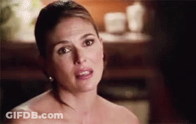 A Woman Without A Shirt Is Making A Funny Face While Looking At The Camera . GIF