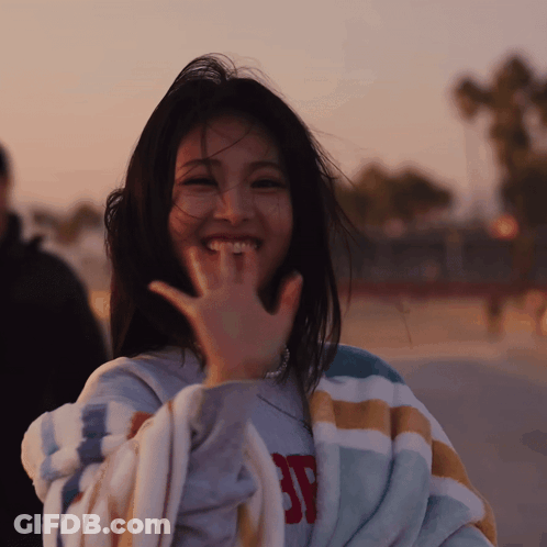 A Woman Wrapped In A Striped Blanket With The Letter Sp On It GIF