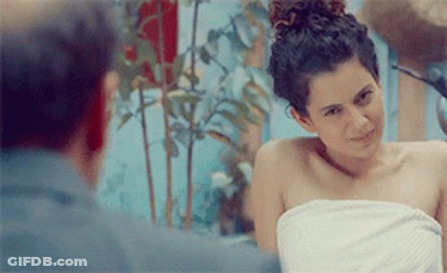 A Woman Wrapped In A White Towel Looks At The Camera GIF