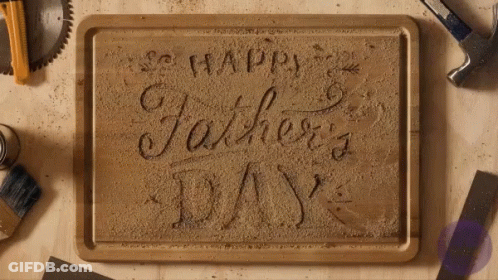 A Wooden Cutting Board With The Words Happy Father 'S Day Carved Into It GIF