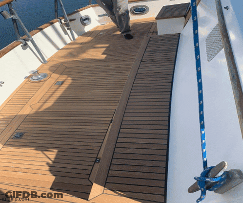 A Wooden Deck On A Boat With A Blue Rope Hanging From The Side GIF
