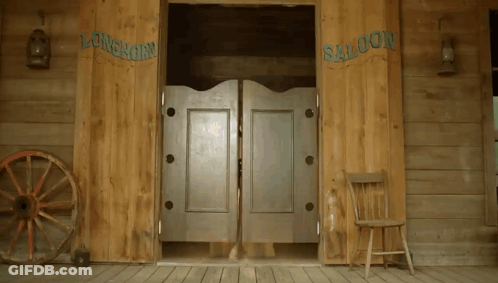A Wooden Saloon With A Wagon Wheel And A Chair GIF