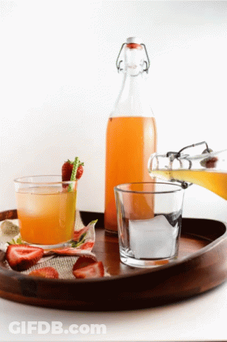 A Wooden Tray With A Bottle Of Juice And A Glass On It GIF