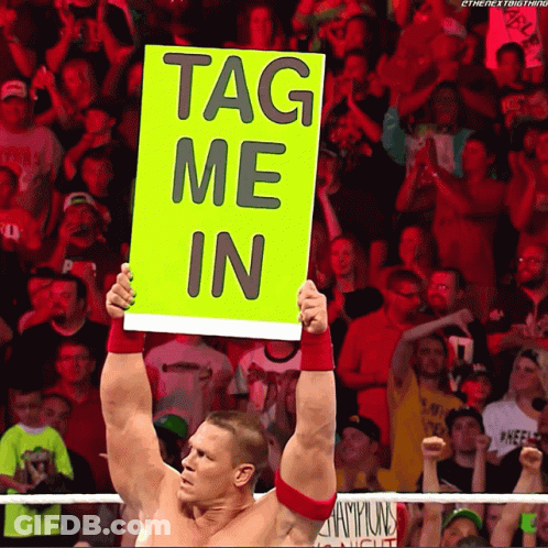 A Wrestler Holds Up A Sign That Reads Tag Me In GIF