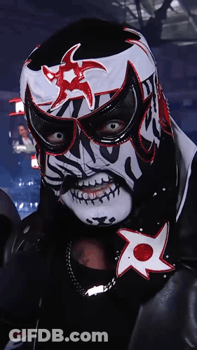 A Wrestler In A Black And White Mask With A Red Star On It GIF