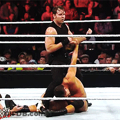 A Wrestler In A Black Tank Top Is Wrestling Another Wrestler GIF
