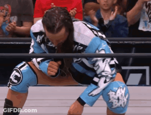 A Wrestler In A Blue And White Uniform With Raw Written On His Knees GIF