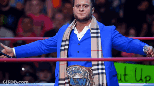 Wrestler In Blue Suit And Scarf With Shut Up Sign GIF