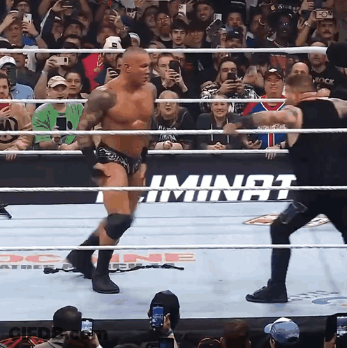 A Wrestler In A Ring With A Sign That Says ' Iminat ' On It GIF