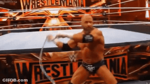 A Wrestler In A Ring With A Sign That Says Wrestlemania GIF