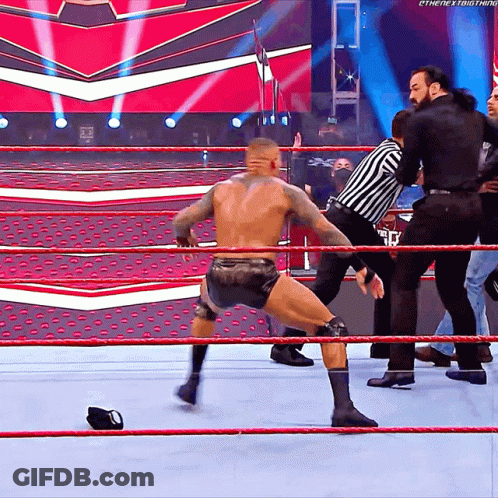 A Wrestler In A Wrestling Ring With A Referee Behind Him And The Word Ethenext Thing On The Bottom Right GIF