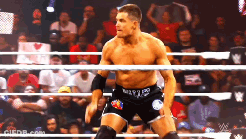 A Wrestler In A Wrestling Ring With A Sign In The Background That Says ' I Love You ' GIF