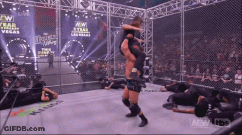 A Wrestler Is Being Lifted In The Air By Another Wrestler In A Ring That Says Kings GIF