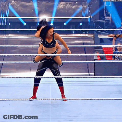 A Wrestler Is Carrying Another Wrestler On His Shoulders In A Wrestling Ring . GIF