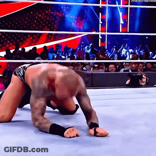 A Wrestler Is Crawling On The Ground In Front Of A Crowd With The Hashtag #Thenextbig Thing GIF