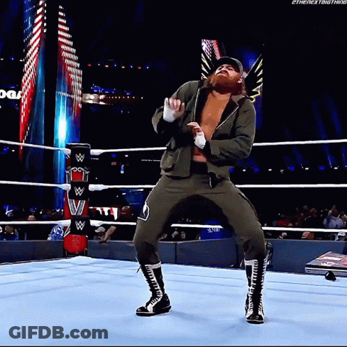 A Wrestler Is Dancing In A Wrestling Ring During A Show . GIF