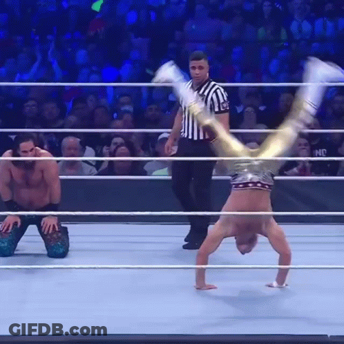 A Wrestler Is Doing A Handstand In A Wrestling Ring GIF