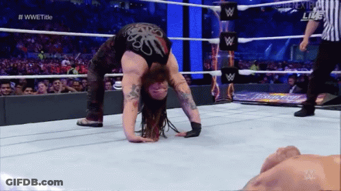 A Wrestler Is Doing A Handstand In The Ring GIF