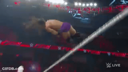 A Wrestler Is Falling Through A Ring While Wearing Purple Shorts GIF