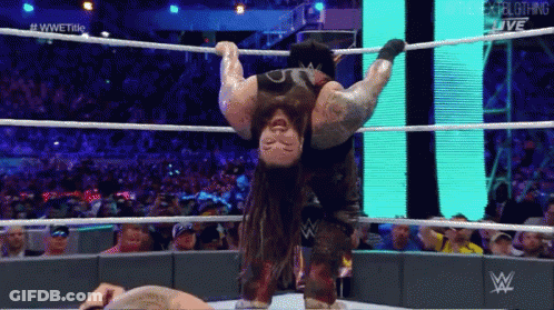 A Wrestler Is Hanging Upside Down In The Ring GIF