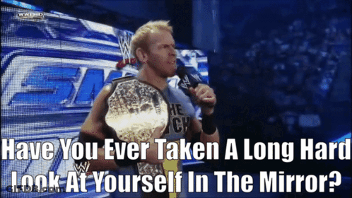 A Wrestler Is Holding A Championship Belt And Talking Into A Microphone GIF