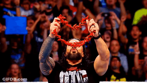 A Wrestler Is Holding A Red Chain Around His Neck . GIF