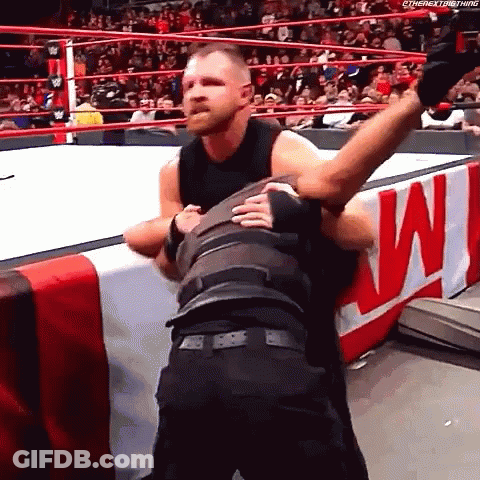 A Wrestler Is Hugging Another Wrestler In A Wrestling Ring During A Match . GIF
