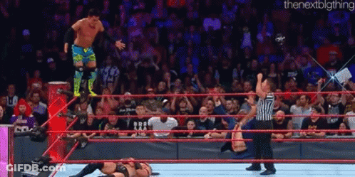A Wrestler Is Jumping Over Another Wrestler In A Wrestling Ring During A Match . GIF