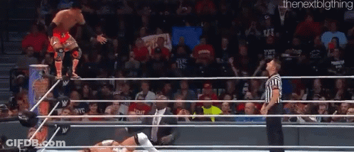 A Wrestler Is Jumping Over The Ropes While A Referee Watches GIF