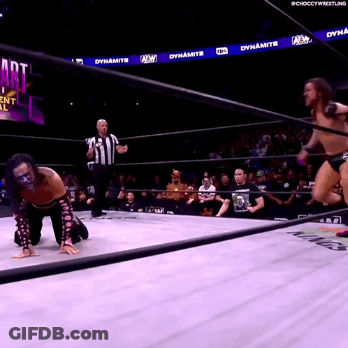 Wrestler Kneeling In Ring While Another Jumps GIF