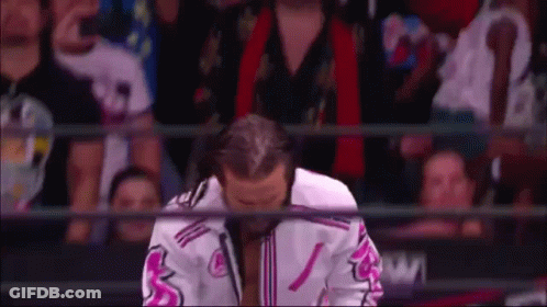 Wrestler Kneeling In Front Of Crowd In Pink And White Jacket GIF