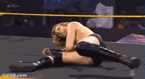 A Wrestler Is Laying On The Ground In A Ring With # 205Live Written On The Bottom GIF