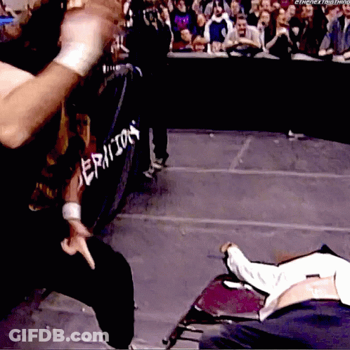 A Wrestler Is Standing In Front Of A Fence That Says Epicon GIF