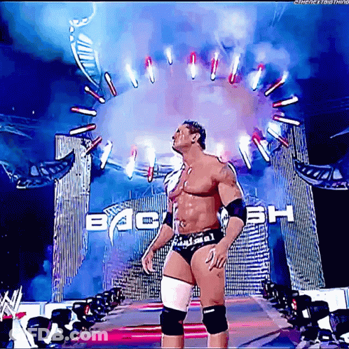 A Wrestler Is Standing In Front Of A Sign That Says Back GIF