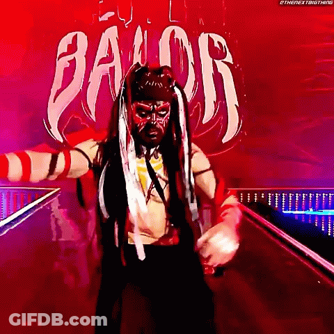 A Wrestler Is Standing In Front Of A Sign That Says " Balor " GIF