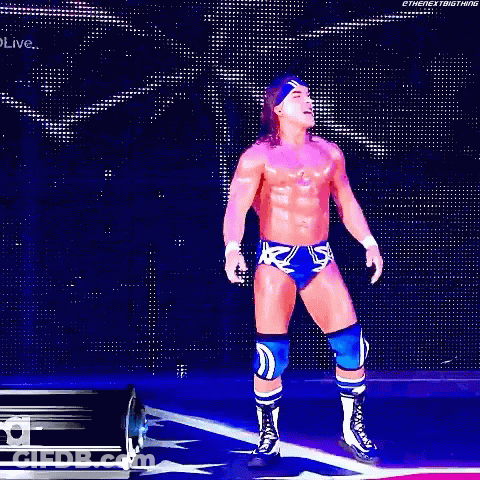 A Wrestler Is Standing In Front Of A Sign That Says Chad Gable GIF