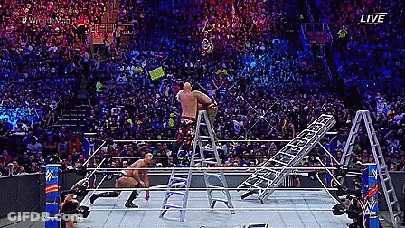 A Wrestler Is Standing On A Ladder In A Wrestling Ring During A Match . GIF